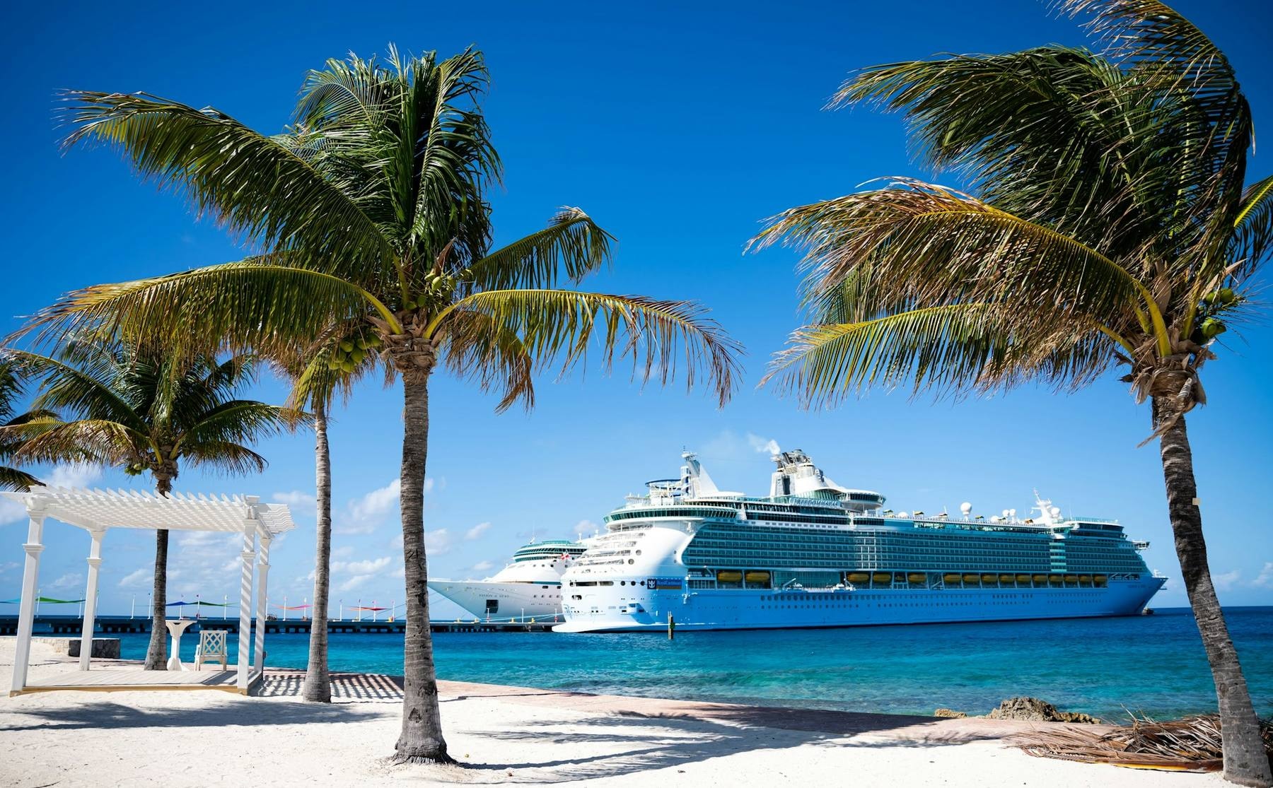 Cruise ship sailing past a Caribbean island at sunset