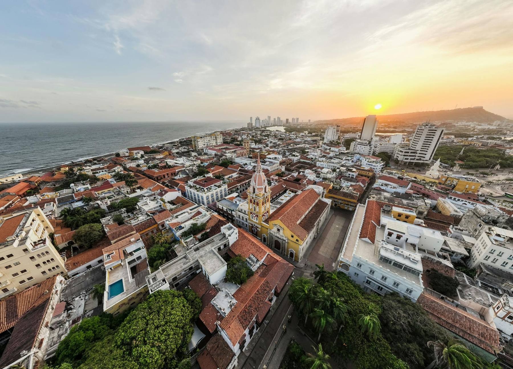 Sunset over the colorful colonial buildings and city walls of Cartagena's Old Town with the Caribbean Sea behind