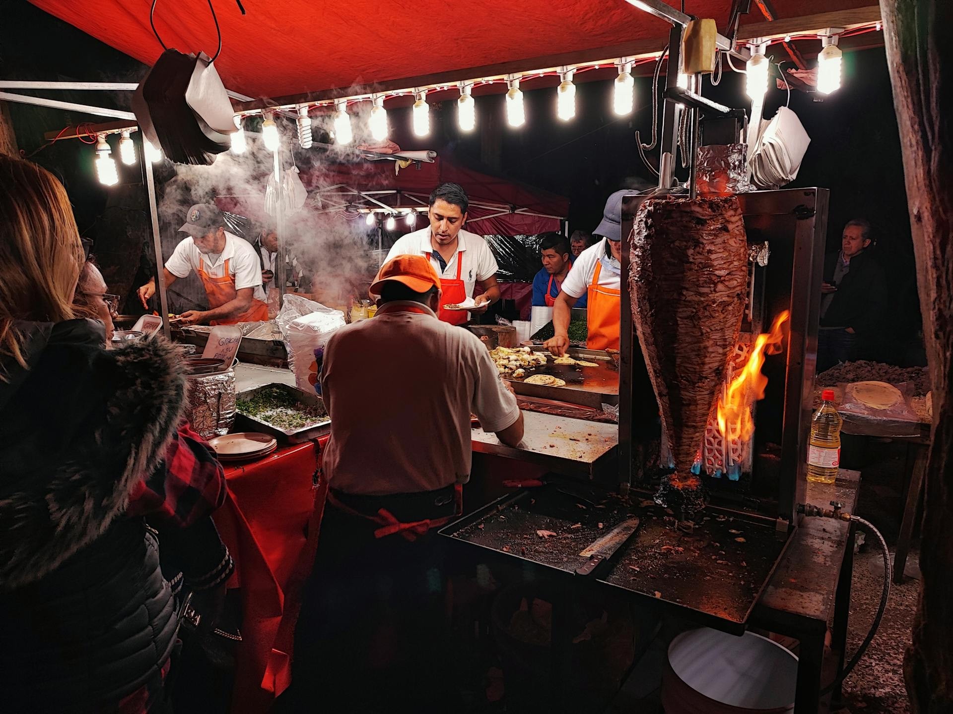 Street tacos al pastor on a Mexico City corner at dusk with the Centro Histórico in the background