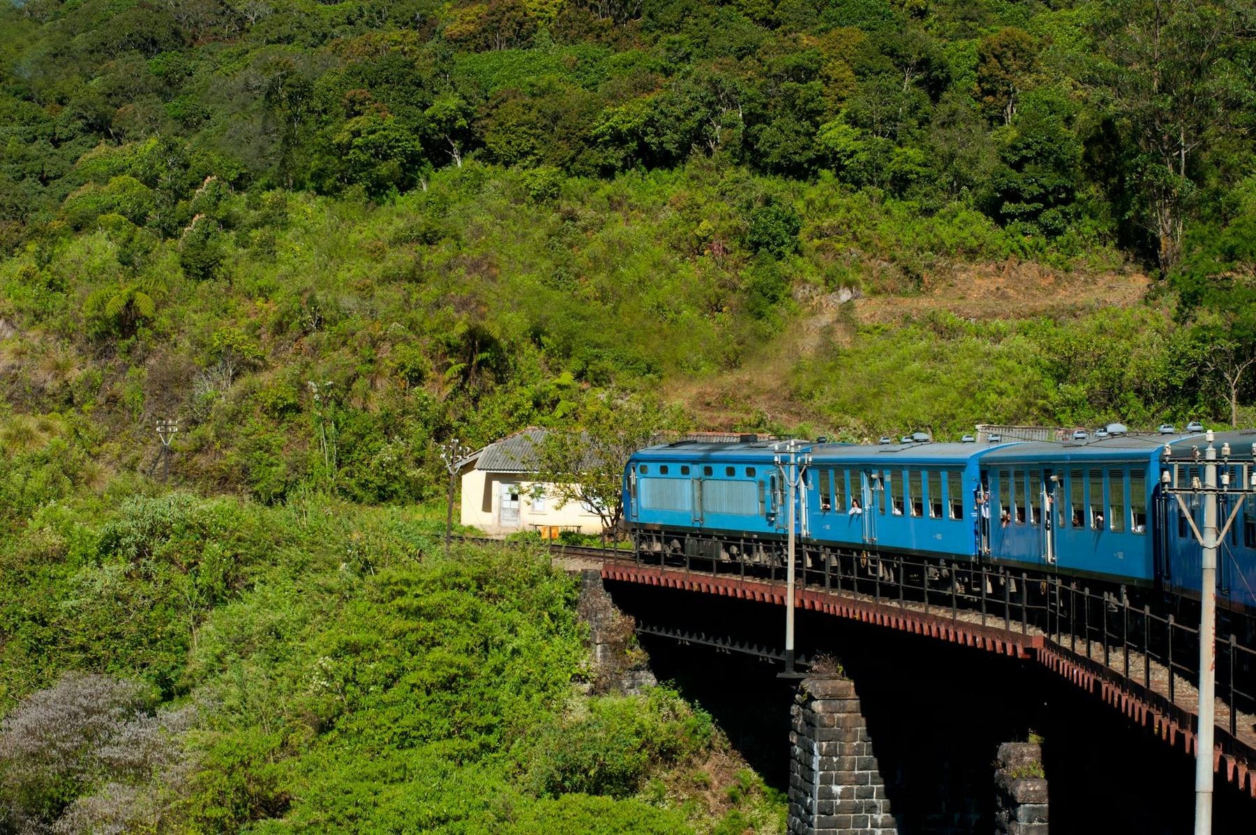 A blue Sri Lanka Railways train crossing the Nine Arches Bridge in Ella, central hill country