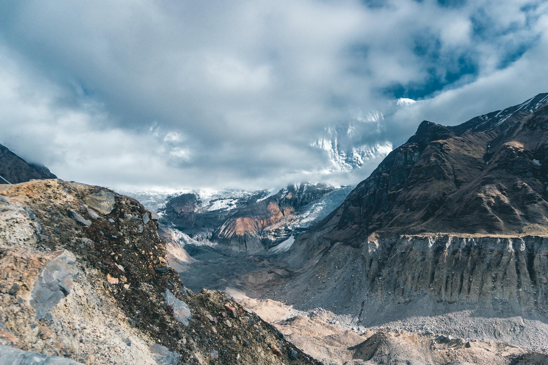 A line of trekkers crossing a suspension bridge above the Khumbu valley with snow-capped Himalayan peaks in the background